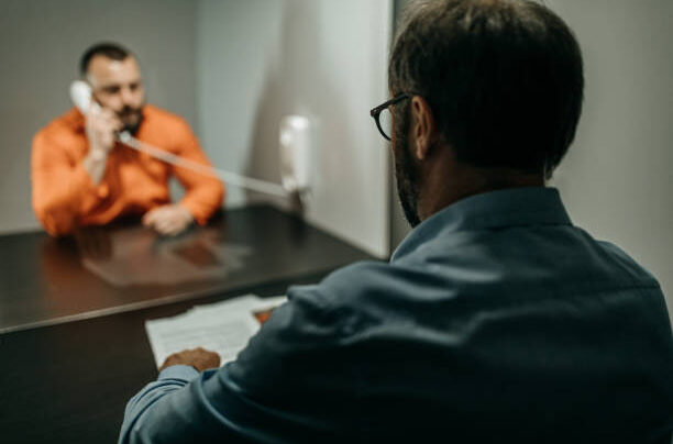 Suspected prisoner talking with his lawyer Early legal advice from a criminal defence solicitor in the UK prevents mistakes